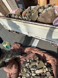 重い庭石を手作業でトラックに積み込む福岡片付け隊のスタッフ