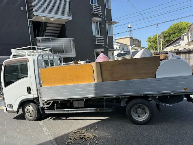 2tロングワイドに、食器棚を底面に寝かせ、ベッドフレーム・猫タワー・脚立を積んだ様子