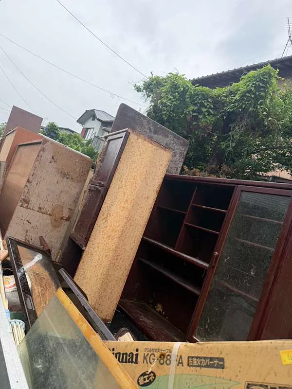 福岡市東区青葉で退去前の不用品を回収したトラック。ガラス扉付きの食器棚・収納棚、大型の木製タンスなど