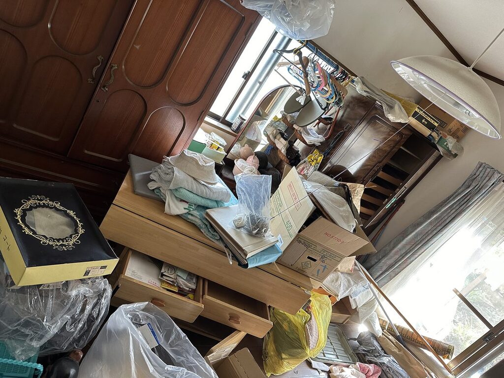 福岡市南区長住の遺品整理前、タンスや鏡台、箱や生活雑貨が残る居室