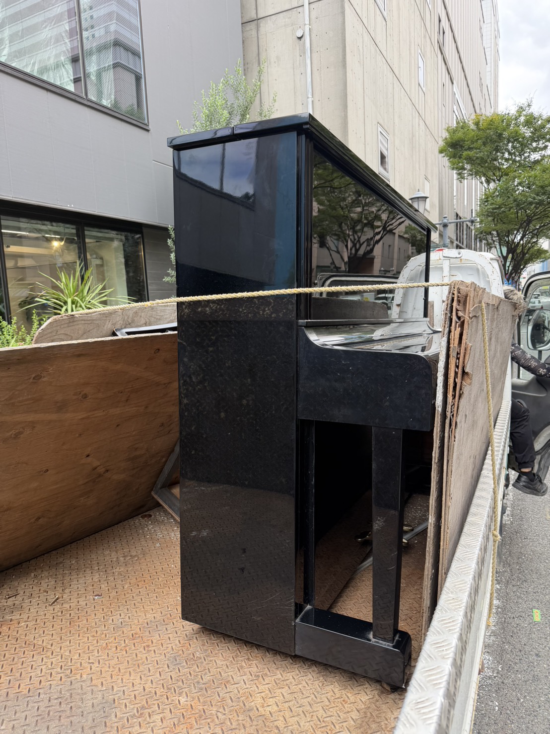 福岡片付け隊が回収し、トラックの荷台に積んだ黒いアップライトピアノ